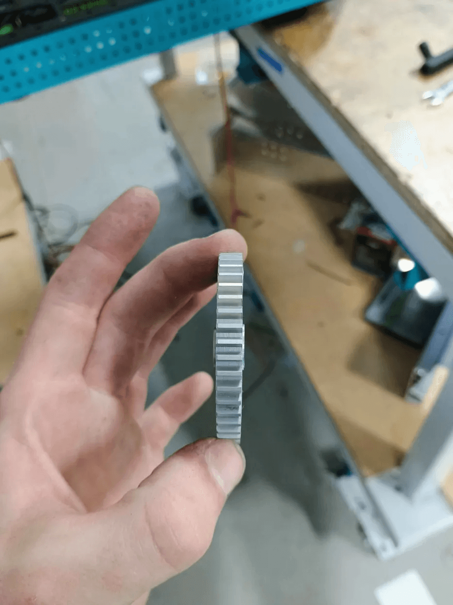 The original thin gear, held up by a student in the shop
